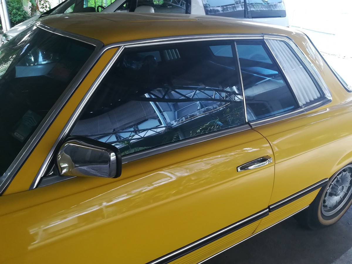 A mechanic carefully installing a new side window using suction cups